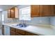 Classic kitchen showcasing wood cabinets and stainless steel sink beneath a bright window at 2161 Denson Sw Ln, Marietta, GA 30008
