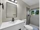 Modern bathroom featuring sleek vanity, toilet, and tiled shower with window at 5207 White Sw Blvd, Mableton, GA 30126