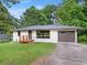 Single-story home featuring painted brick, a front porch, a garage and a well-maintained lawn at 5207 White Sw Blvd, Mableton, GA 30126