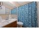 Functional bathroom featuring a pedestal sink, toilet, mirror, and a patterned shower curtain at 761 Robert E Lee Pkwy, Jonesboro, GA 30238