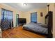 Cozy bedroom featuring wood floors, a comfortable bed, and bright window with patterned curtains at 761 Robert E Lee Pkwy, Jonesboro, GA 30238