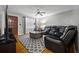 Inviting living room featuring a comfortable leather sofa, ceiling fan, and a decorative area rug at 761 Robert E Lee Pkwy, Jonesboro, GA 30238