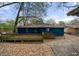 Back view of the blue brick home with a wooden wheelchair ramp surrounded by leaves at 1089 Indale Sw Pl, Atlanta, GA 30310