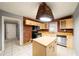 Kitchen has white tile floors, an island, wood cabinets, and a vintage brick oven hood at 1089 Indale Sw Pl, Atlanta, GA 30310