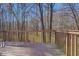 View from the wooden deck showing the property's private, tree-lined backyard at 169 Holly Ct, Loganville, GA 30052