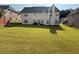 View of spacious backyard with lush green grass, a back patio and a wooden fence at 3139 Tuscan Ridge Dr, Snellville, GA 30039