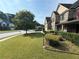 Side view of two-story brick home with red shutters, covered front porch, manicured lawn and landscaping at 3139 Tuscan Ridge Dr, Snellville, GA 30039