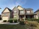 Two-story brick home with red shutters, covered front porch, manicured lawn and landscaping at 3139 Tuscan Ridge Dr, Snellville, GA 30039