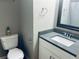 Bathroom featuring a gray countertop, white cabinets, mirror, towel rack and a white toilet at 4007 Stacy Ln, Snellville, GA 30039