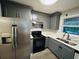 Modern kitchen with stainless steel appliances, gray cabinetry, and quartz countertops at 4007 Stacy Ln, Snellville, GA 30039