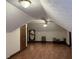 A finished attic featuring wood flooring, two light fixtures, a mirror, and a chaise lounge at 4640 Calleigh Way, Snellville, GA 30039
