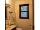 Bathroom featuring a mirror, sink, toilet, and window with blinds and decorative butterflies at 4640 Calleigh Way, Snellville, GA 30039