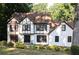 Charming Tudor style home with white exterior, dark trim, and well-manicured landscaping at 4640 Calleigh Way, Snellville, GA 30039