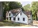 Two-story Tudor style home with white brick and brown trim near a wooded area at 4640 Calleigh Way, Snellville, GA 30039