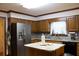 Well-lit kitchen featuring a stainless steel refrigerator, granite countertops, and wooden cabinets at 4640 Calleigh Way, Snellville, GA 30039