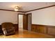 Living room with wood paneling, hardwood floors, and an accent chair at 4640 Calleigh Way, Snellville, GA 30039
