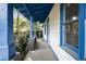 Detailed side view of a home's white siding, blue trim, a porch with support beams, and a glimpse of the yard at 1321 Mcclelland Ave, Atlanta, GA 30344