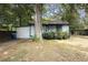 View of a white house with blue trim, surrounded by trees and a lawn, creating a serene, private setting at 1321 Mcclelland Ave, Atlanta, GA 30344