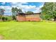 Lush backyard view of the house featuring a deck, lawn, and mature trees at 1342 Peggy Nw Ln, Conyers, GA 30012