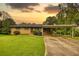 Charming brick home with mature trees, a well-manicured lawn, and a covered carport at 1342 Peggy Nw Ln, Conyers, GA 30012