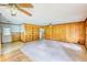 Cozy living room with wood paneling, a built-in bookshelf, and dual ceiling fans at 1342 Peggy Nw Ln, Conyers, GA 30012