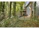 Backyard view of the home shows a deck with stairs, gray siding, and partially wooded lot at 1496 Meadowlark Dr, Decatur, GA 30032