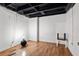 An unfinished basement with wooden floors, exposed ceiling and white painted walls at 1496 Meadowlark Dr, Decatur, GA 30032