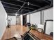 Unfinished basement featuring hardwood floors and black-painted ceiling with exposed ducts and access to other rooms at 1496 Meadowlark Dr, Decatur, GA 30032