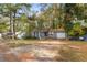 View of house with gray siding, small front porch, attached garage, and yard covered in autumn leaves at 1496 Meadowlark Dr, Decatur, GA 30032