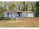 Charming single-story home featuring gray siding, front porch and attached garage, surrounded by mature trees at 1496 Meadowlark Dr, Decatur, GA 30032