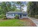 Charming single-story home featuring light gray siding, blue shutters, and a cozy front yard with mature trees at 2436 Clarissa Nw Dr, Atlanta, GA 30318