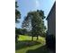 View of a large treed lawn with a portion of a home visible on the right side of the shot at 2580 Three Wood Dr, Villa Rica, GA 30180