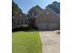 Charming two-story brick home featuring an attached two-car garage and well-manicured lawn at 2580 Three Wood Dr, Villa Rica, GA 30180