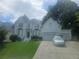 Elegant white brick home with a manicured lawn, multiple car garage, and a beautiful front entrance at 9035 Sandorn Dr, Roswell, GA 30075