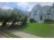 Lush front yard with a beautiful lawn leading up to an elegant home, framed by mature trees and landscaping at 9035 Sandorn Dr, Roswell, GA 30075