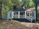 Charming blue home with a covered front porch surrounded by mature trees at 1417 Graymont Sw Dr, Atlanta, GA 30310