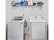 Bright laundry room with modern, white appliances and storage shelf above the units at 1742 Weatherbrook Cir, Lawrenceville, GA 30043