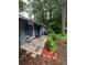 Exterior view showcasing the front porch, blue shutters, and lush greenery of this cozy home at 3530 Fairlane Nw Dr, Atlanta, GA 30331