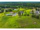 A broad aerial perspective captures the home, outbuildings, expansive lawn, and surrounding verdant landscape at 500 Coleman Mill Rd, Carrollton, GA 30116