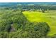 Lush aerial view of a vast, verdant property seamlessly merging fields and dense woodlands at 500 Coleman Mill Rd, Carrollton, GA 30116