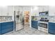 Stylish kitchen features white and blue cabinets, stainless steel appliances, and patterned tile floors at 500 Coleman Mill Rd, Carrollton, GA 30116