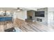Open-concept living room with a stone fireplace, modern ceiling fan, and an open view into the kitchen at 500 Coleman Mill Rd, Carrollton, GA 30116