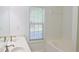 A bathroom featuring a double sink vanity, a bathtub, and a window at 3761 Lake Point Blvd, Suwanee, GA 30024