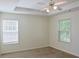 Cozy bedroom featuring neutral walls, carpet flooring, tray ceiling, and bright windows at 3761 Lake Point Blvd, Suwanee, GA 30024