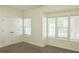 This bedroom features neutral carpeting, built-in closet, and large window at 3761 Lake Point Blvd, Suwanee, GA 30024