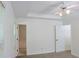 Neutral bedroom featuring a ceiling fan, tray ceiling and an adjoining bathroom at 3761 Lake Point Blvd, Suwanee, GA 30024