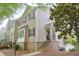 Traditional townhome featuring brick accents, dark shutters, and a quaint covered entryway with stairs at 3761 Lake Point Blvd, Suwanee, GA 30024