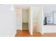 Inviting hallway with hardwood floors, staircase, and a glimpse into a modern kitchen with stainless appliances at 3761 Lake Point Blvd, Suwanee, GA 30024