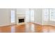 Well-lit living area featuring a fireplace, hardwood floors, and large windows offering a bright and airy feel at 3761 Lake Point Blvd, Suwanee, GA 30024