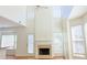 Living room with soaring ceilings, fireplace, a ceiling fan, and large windows for ample natural light at 3761 Lake Point Blvd, Suwanee, GA 30024